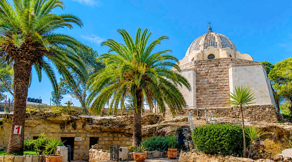 A wide angle image of the entrance to the Chapel of the Shepherds’ Field with palm trees in the Holy Land
