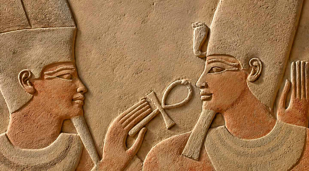 Wall engraving of two ancient Egyptians facing each other and holding The Ankh Cross