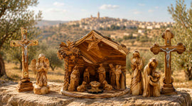 Handcrafted olive wood Nativity scene, crucifixes, and Holy Family figures displayed outdoors with Bethlehem on the hills in the background