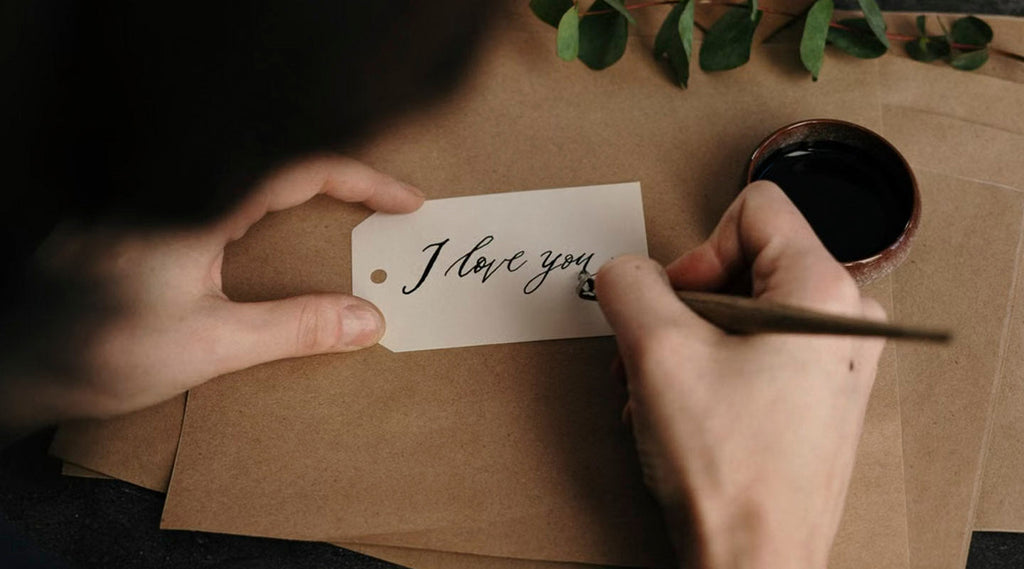 Hand writting "I love you" on a white card