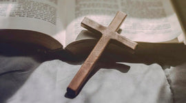 Wooden cross laying down on an open Bible