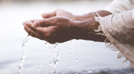 Close-up of a person's hands holding water against a blurred background
