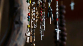 Close-up of rosary beads with crosses and colorful beads against a blurred background