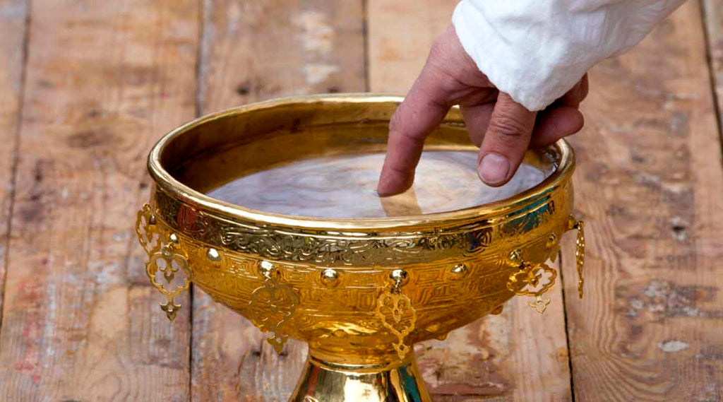 Hand touching a Blessed Holy Water from the Holy Land