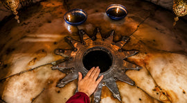 A pilgrim touches the Star of Bethlehem beneath the Nativity Altar inside the Church of the Nativity in Bethlehem