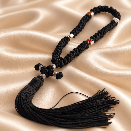 Black 50-knot Chotki with red cross beads and silver-tone accents on a neutral background
