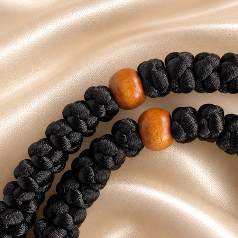 Close view of black 50-knot Chotki with wooden beads and bronze-tone cross