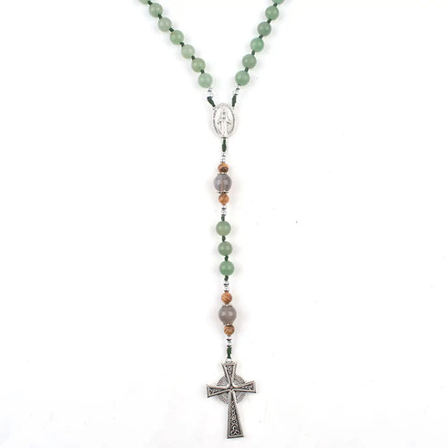 Green aventurine and jade rosary with detailed Celtic cross and Miraculous Virgin Mary centrepiece on white surface.
