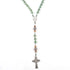 Green aventurine and jade rosary with detailed Celtic cross and Miraculous Virgin Mary centrepiece on white surface.