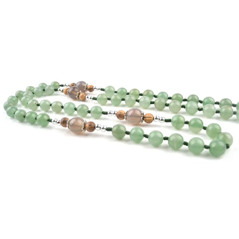 Green gemstone rosary beads on a white background.
