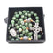 A handmade Irish Rosary with green aventurine and jade beads, a Virgin Mary medal and Celtic cross, laid in a black box.
