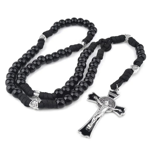 Handmade men's rosary with black paracord and durable acrylic beads, placed on white surface.