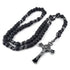 Handcrafted black paracord rosary with 12mm matte beads and St.Benedict cross, laid on white surface.