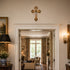 Living room with a cross on the wall, lamp, and view into another room.