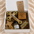 Catholic prayer gift set contents in open box: wooden cross, holy water, rosary, certificate
