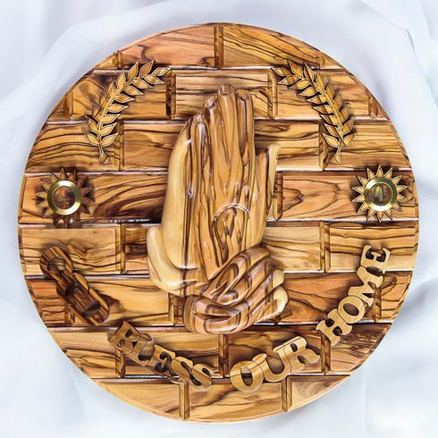 Olive wood blessing plate to hang on a wall with 'God Bless Our Home' inscription, praying hands and Holy Soil shown in detail.