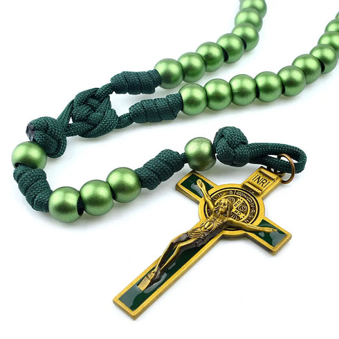 Handcrafted green paracord rosary with 12mm shiny acrylic beads and Benedict cross, laid on white surface.