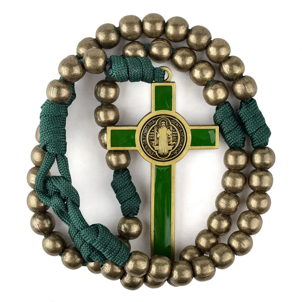 A bronze-coloured 12mm iron bead rosary with green St. Benedict crucifix and paracord laid on white surface.
