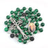Malachite 8mm bead rosary with lava stone accents and Holy Family centrepiece, against white background.