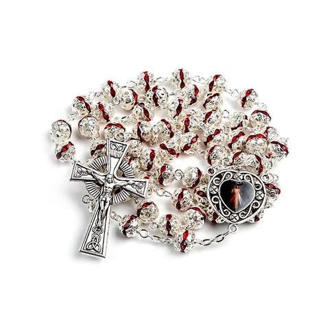 A silver-plated rosary with red rhinestone beads and a heart-shaped Immaculate medallion with Celtic Crucifix.