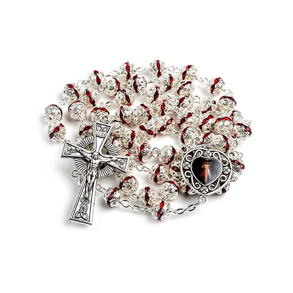 A silver-plated rosary with red rhinestone beads and a heart-shaped Immaculate medallion with Celtic Crucifix.