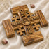 Jerusalem Cross from olive wood, featuring engraved blessings and Jesus Christ's face, resting on a white surface.
