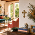 Living room with a cross on the wall, books, and decorative items.