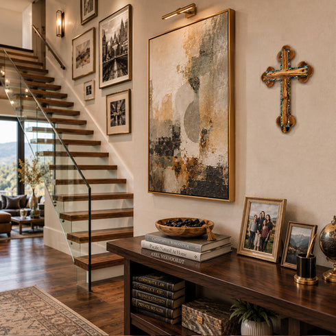 Staircase with a wall of framed pictures and a console table with books and decor.
