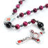 Red Tiger Eye rosary with Divine Protection theme and Child Jesus emblem centrepiece, displayed on white background.