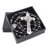 Saint Benedict rosary with dark hematite beads and silver crucifix in a black box, laid on white surface.