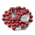 Rosary of Seven Sorrows featuring dark red 8mm rose-scented wooden beads, laid on white surface.