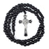 Black beaded rosary with a silver Saint Benedict cross on a white background