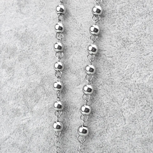 4mm stainless steel rosary beads, laid on grey background.