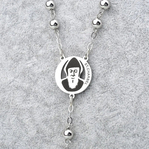 Stainless steel rosary with St. Charbel medal displayed on a clean grey background.