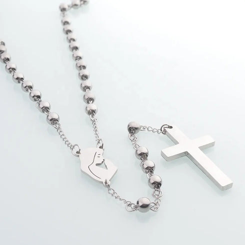 Rosary with shiny stainless steel beads and Virgin Mary medal, set on white backdrop.