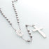 Rosary with shiny stainless steel beads and Virgin Mary medal, set on white backdrop.