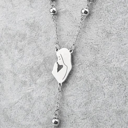 Stainless steel rosary with Virgin Mary centrepiece, neatly displayed on grey background.