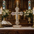 Decorative cross on an altar with candles, flowers, and stained glass windows in the background.
