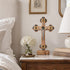 Olive wood Apostles crucifix hanging on a bedroom wall as part of a calm, traditional Christian home interior