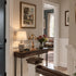 Olive wood Apostles crucifix on a hallway wall with framed artwork and everyday furnishings in a bright home