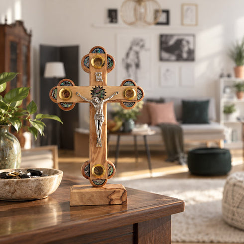 Olive wood Apostles crucifix displayed among framed pictures on the wall of a comfortable family living room