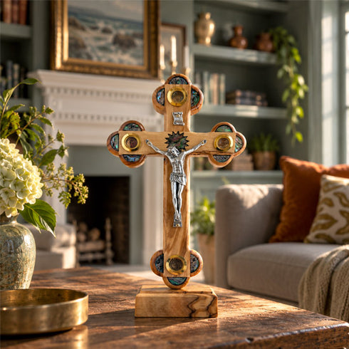Olive wood Apostles crucifix hanging among framed artwork in a warmly furnished sitting room