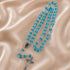 A beaded rosary with bright turquoise-blue glass beads and a silver-tone crucifix, on a beige satin fabric background.