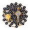 Black glass bead rosary with gold accents and St Benedict crucifix on a white background.