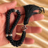 Hand holding a black 50-knot Komboskini with silver-tone separators and red cross