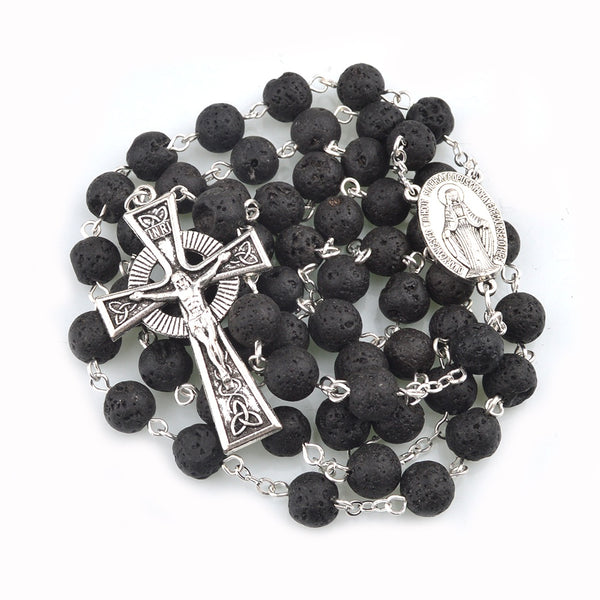 Black lava stone rosary with silver Celtic crucifix and Miraculous medal on a white background