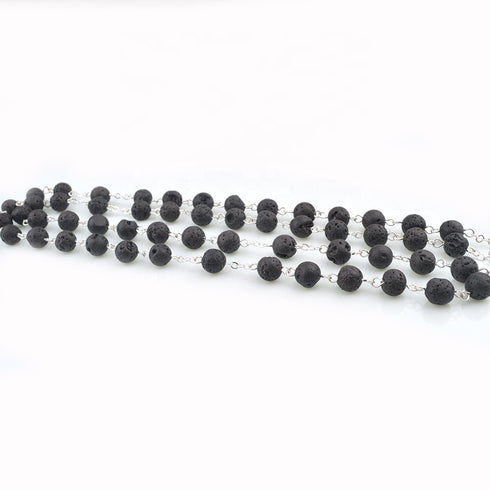 Black lava stone rosary beads on a white background