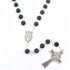 Black lava stone rosary with silver Celtic cross and Miraculous medal on a white background.
