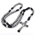 St. Benedict Rosary with silver beads and black paracord on a white background