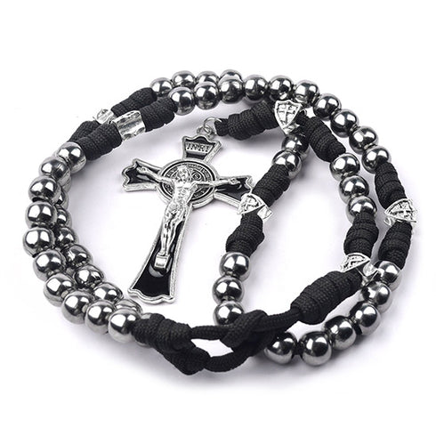 St. Benedict Rosary with silver steal beads and black cord on a white background.
